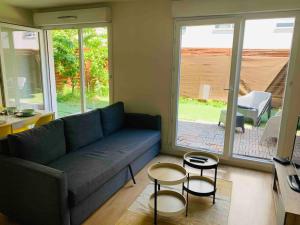 a living room with a couch and two tables at Bel appartement terrasse+jardin in La Courneuve