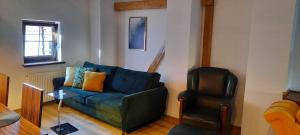uma sala de estar com um sofá azul e uma cadeira em Komfortowy Apartament w Młynie Mrągowo em Mrągowo