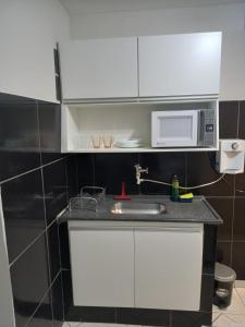uma cozinha com um lavatório e um micro-ondas em Apartamento 1010 em Goiânia