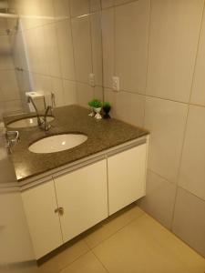 a bathroom with a sink and a mirror at Apartamento 1010 in Goiânia