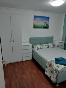 Apartament litoral في ساتورن: غرفة نوم مع سرير وخزانة بيضاء