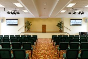 una sala de conferencias vacía con sillas y un escenario en Willowbank Resort en Somerset