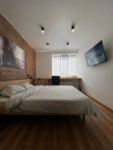 a bedroom with a bed and a brick wall at Brick Apart Melnyka10 in Ivano-Frankivsʼk