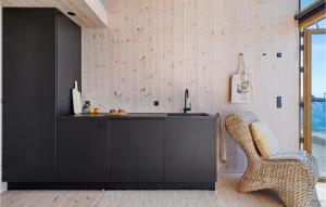 eine Küche mit einem schwarzen Schrank und einem Stuhl in der Unterkunft Gorgeous Apartment In Aarhus C With Harbor View in Arhus