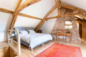 a bedroom with a bed and a table with a chair at Château D'arry Maison de Vacance in Arry