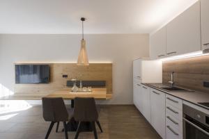 een keuken met een tafel en stoelen in een kamer bij Residence Sonja - Apartment Picea in Rablà