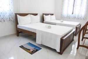 two beds in a room with a magazine on the floor at Sanmi Home Rentals Battaramulla in Battaramulla
