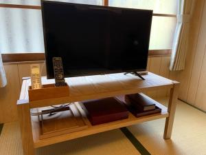 TV de pantalla plana sobre una mesa de madera en Sumireya - Vacation STAY 55743v, en Takatsuki