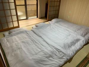 1 cama blanca grande en una habitación con ventana en Sumireya - Vacation STAY 55743v, en Takatsuki