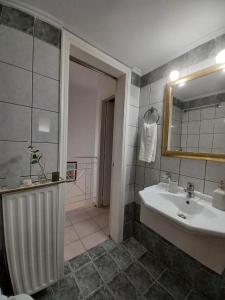 a bathroom with a sink and a mirror at IL TRAMONTO APARTMENTs 2 in Kanali +33 photos