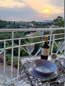stół z butelką wina i kieliszkami na balkonie w obiekcie IL TRAMONTO APARTMENTs 2 w Kanalionie