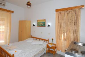 ein kleines Schlafzimmer mit einem Bett und einer Küche in der Unterkunft Stone House in Mythimna