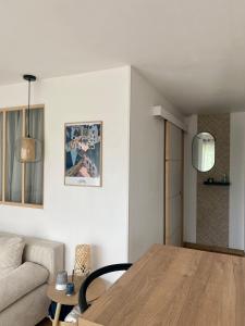 ein Wohnzimmer mit einem Tisch und einem Sofa in der Unterkunft Appartement cosy Le Saint Gildas, à proximité immédiate centre ville, place de stationnement, Netflix in Vannes