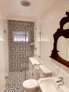a white bathroom with a toilet and a sink at Primo farm in Windmeul