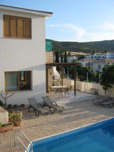een villa met een zwembad en een huis bij Villa Pergia Latchi in Polis Chrysochous