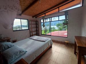 1 dormitorio con cama y ventana grande en Casa de Campo "Villa Maria", en Sauce