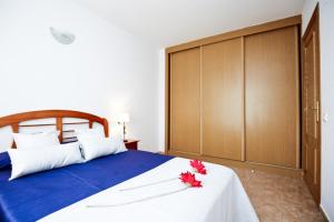 a bedroom with a large bed with red leaves on it at New Juncos 2 Planetcostadorada in La Pineda
