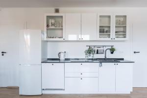 a white kitchen with white cabinets and a sink at Rybical 42 in Rybical