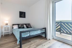 a bedroom with a bed and a large window at Rybical 42 in Rybical +62 photos