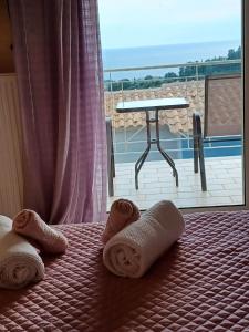 łóżko z ręcznikami i widokiem na patio w obiekcie IL TRAMONTO APARTMENTs 2 w Kanalionie