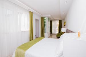 a white bedroom with a large bed and a window at Giorgio Boutique Hotel in Sliema