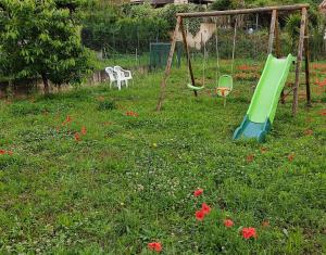 einen Spielplatz mit einer grünen Rutsche auf einem Blumenfeld in der Unterkunft Appartement L'oranger in Pégomas