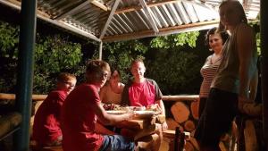 un grupo de personas sentadas alrededor de una mesa comiendo comida en B&B Ruzan, en Yeghegnadzor