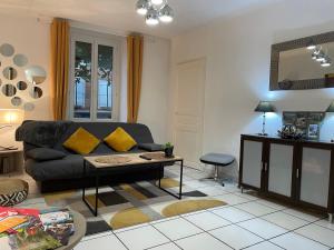 uma sala de estar com um sofá preto e uma mesa em T2 plein centre au 1er étage avec parking privé em Millau