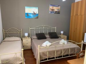 1 dormitorio con 2 camas y toallas. en Cas'Ilenia Lido Azzurro, en Porto Empedocle