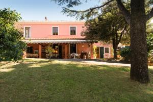 una imagen de una casa rosa con un patio en B&B Villa il Poggetto, en Venturina Terme