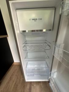 an empty refrigerator with its door open in a kitchen at La Parenthèse in Rouen