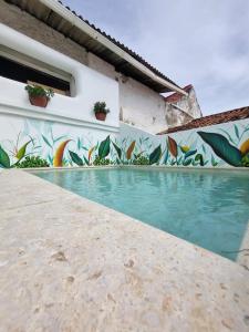 un mural en el lateral de un edificio con piscina en Casa Cordoba Román en Cartagena de Indias