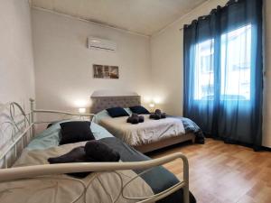 a bedroom with two beds and a large window at L'hypercentre - Clim - Terrasse - WIFI in Miramas