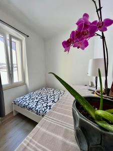 a flower in a vase on a bed in a room at Apartment JURIĆ in Lovran