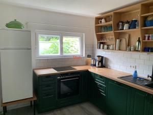 uma cozinha com armários verdes e uma janela em Auszeit Haus em Grassau