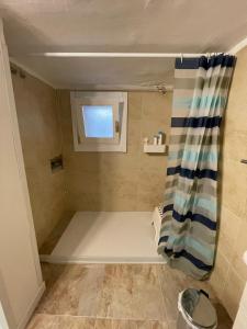 a small bathroom with a shower with a window at Sedici Scalini in Taranto