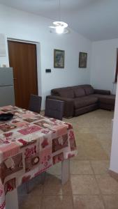 a living room with a table and a couch at Domus Claudio in Villam in Pomezia