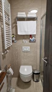 a bathroom with a white toilet and towels at Tuzla Trg - Tuzla Square in Tuzla