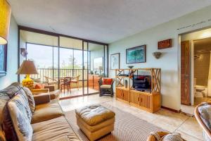 sala de estar con sofá y TV en Maunaloa Shores 403, en Hilo