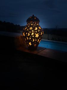 a black vase with stars on it in the dark at Torre Costa Brava Private pool in Garrigás +20 photos