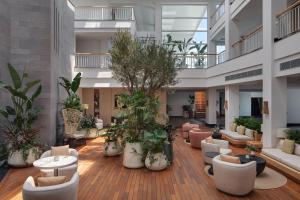 Doria Hotel Bodrum-City Center في بيتيس: لوبي كبير فيه كنب واشجار ونباتات