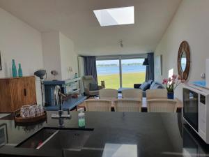 een keuken en een woonkamer met uitzicht op de oceaan bij Cosy holiday home on Lake Veere with the beach right at your doorstep in Kamperland