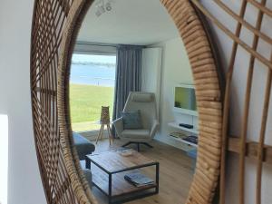 een woonkamer met een stoel en een spiegel bij Cosy holiday home on Lake Veere with the beach right at your doorstep in Kamperland