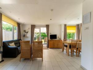 un soggiorno con divano, tavolo e sedie di Beautiful holiday home in Baarland with private garden a Baarland