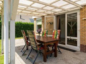un tavolo e sedie in legno su un patio di Beautiful holiday home in Baarland with private garden a Baarland