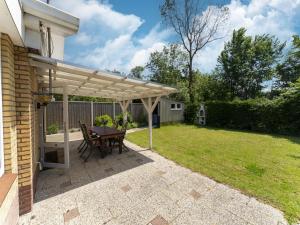 patio con pergolato in legno e tavolo di Beautiful holiday home in Baarland with private garden a Baarland