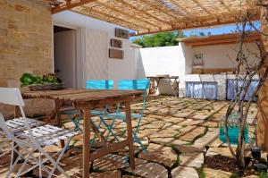 a patio with a wooden table and chairs at I Trulli Sul Mare in Trani