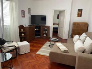 a living room with a couch and a flat screen tv at Apartment Elanda Downtown in Zadar