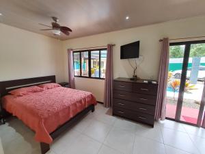a bedroom with a bed and a dresser and a television at Casa Uvita Bay in Uvita
