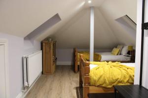 un dormitorio en el ático con 2 camas en un ático en 5 star Apartment, en Londres